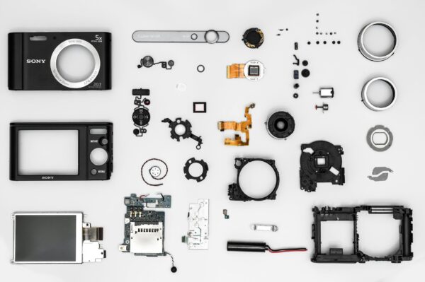pexels photo 1476316 1476316 Flat lay of various disassembled camera components on a white background.